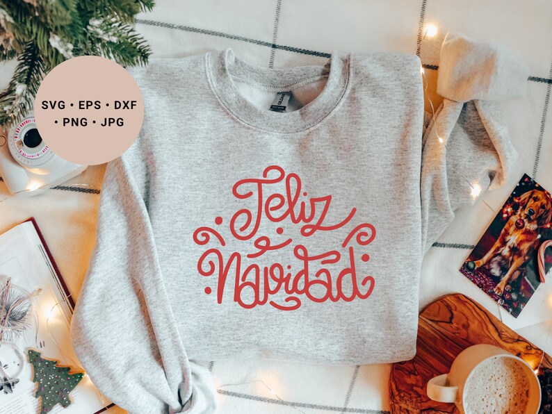 May include: A gray sweatshirt with the text "Feliz Navidad" in red cursive lettering.
