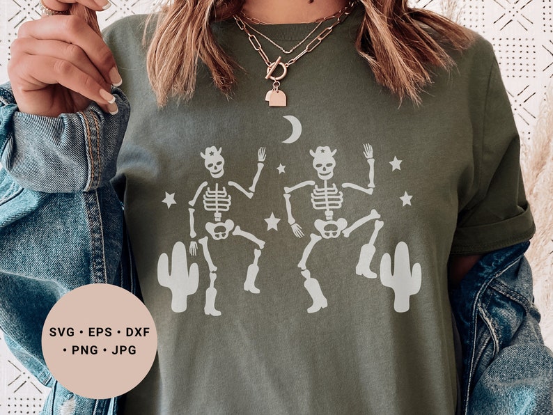 May include: A green t-shirt with a white design of two skeletons wearing cowboy hats and boots, dancing in front of cacti and stars. The text "SVG - EPS - DXF - PNG - JPG" is on a white circle in the lower left corner of the image.
