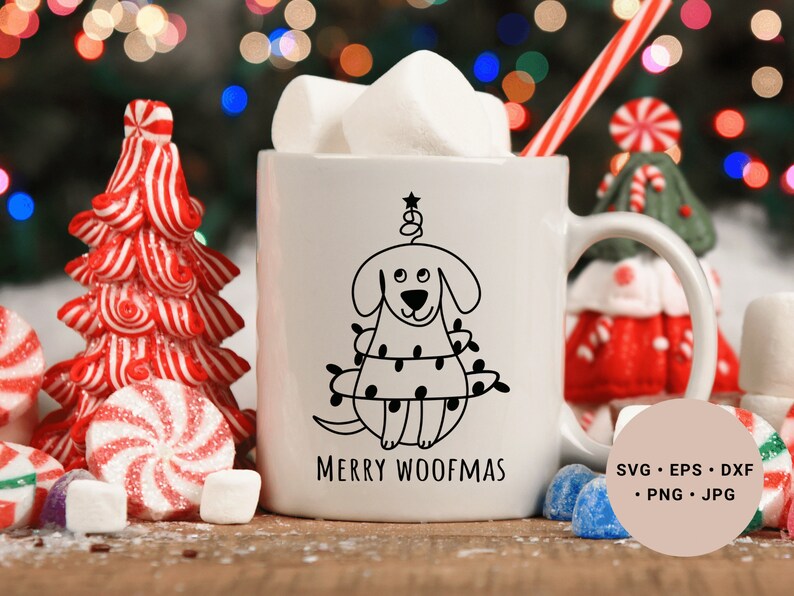 May include: White ceramic mug with a black and white illustration of a dog wearing a Christmas tree costume. The text "Merry Woofmas" is printed below the illustration. The mug is surrounded by candy canes, marshmallows, and a small Christmas tree.