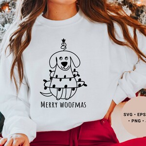May include: White sweatshirt with a black and white illustration of a dog wearing Christmas lights and the text "Merry Woofmas".