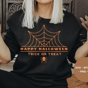 K&ouml;nnte beinhalten: Ein schwarzes Sweatshirt mit einem orangefarbenen Grafikdesign eines Spinnennetzes und dem Text "Happy Halloween Trick or Treat".