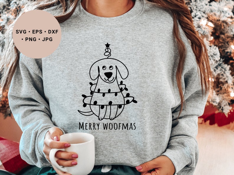 May include: A gray sweatshirt with a black and white illustration of a dog wearing Christmas lights. The text "Merry Woofmas" is printed below the illustration.