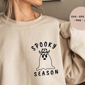 May include: A beige sweatshirt with a black graphic design of a ghost wearing a cowboy hat and the text "Spooky Season".
