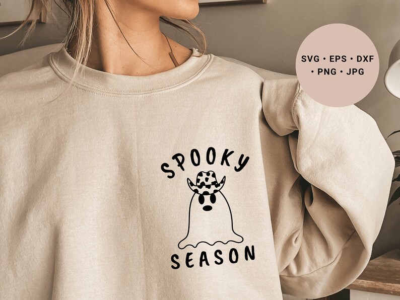 May include: A beige sweatshirt with a black graphic design of a ghost wearing a cowboy hat and the text "Spooky Season".