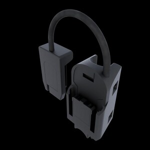 May include: A dark gray, plastic device with a curved handle. The device is composed of two connected parts, one rectangular and the other with a rectangular opening. The handle arches over the opening.