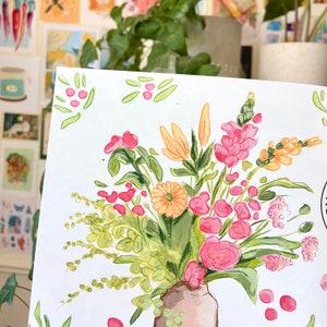 K&ouml;nnte beinhalten: Aquarellmalerei eines lebendigen Blumenstrau&szlig;es in einer braunen Vase. Das Arrangement zeigt rosa, orange und gelbe Blumen mit gr&uuml;nem Laub. Das Kunstwerk befindet sich auf wei&szlig;em Papier, mit zus&auml;tzlichen floralen Akzenten.