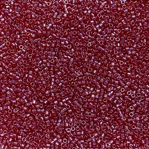 May include: A close-up of a large pile of small, cylindrical beads. The beads are a deep burgundy colour with a slightly iridescent sheen. They are densely packed together, creating a textured surface.