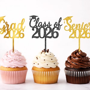 Könnte beinhalten: Drei Cupcakes mit Abschluss-Toppern. Die Topper lesen "Grad 2026", "Class of 2026" und "Senior 2026". Die Cupcakes haben rosa, weiße und Schokoladen-Glasur, verziert mit Streuseln und Schokoladenstückchen.