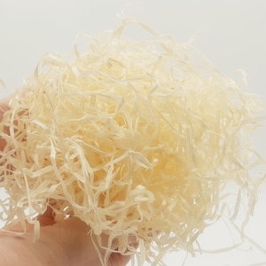 May include: A close-up of a pile of white shredded paper, commonly used as packing material for fragile items.