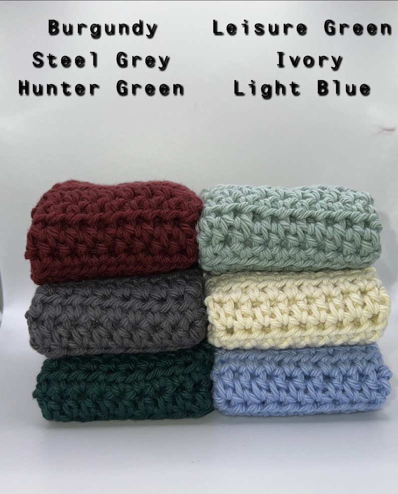 May include: Six crocheted squares stacked on top of each other. The squares are in the following colors from top to bottom: burgundy, steel grey, hunter green, leisure green, ivory, and light blue.