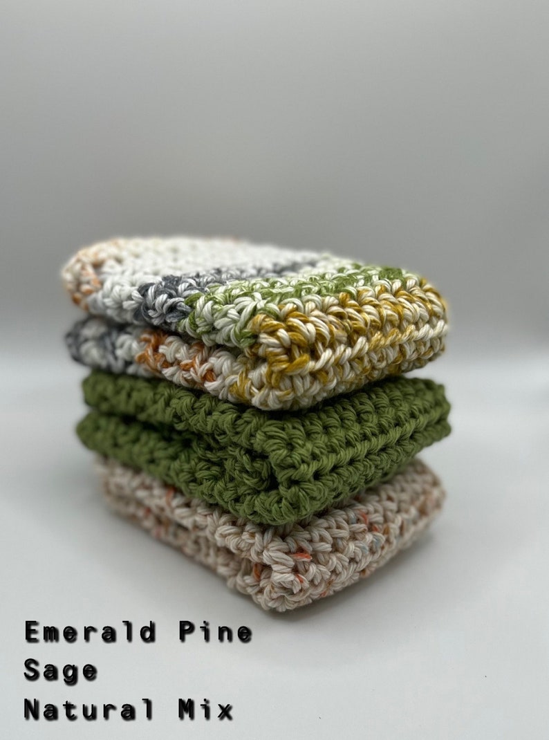 May include: A stack of four crocheted dishcloths in different colors: emerald pine, sage, natural mix, and a multi-colored mix. The dishcloths are made with cotton yarn and are perfect for cleaning dishes and other surfaces.