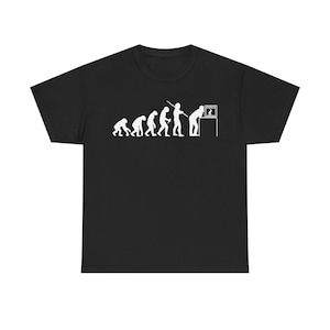 Op de afbeelding: Zwart T-shirt met een witte afbeelding van de evolutie van de mens, eindigend met een man die gebogen over een televisie zit.