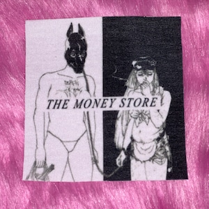 May include: Black and white illustration of two figures. The figure on the left is wearing a dog mask and holding a leash. The figure on the right is wearing a hat and smoking a cigarette. The text "THE MONEY STORE" is printed across the middle of the image.
