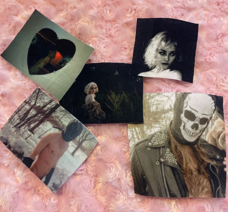 May include: Five different fabric patches with various images. One patch features a heart shape with a woman inside. Another patch features a woman with short blonde hair. A third patch features a person with a skull mask. A fourth patch features a person in a snowy forest. The fifth patch features a woman in a forest.