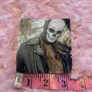 May include: A black and white skull mask with a leather jacket. The image is in a vintage style with a sepia tone.