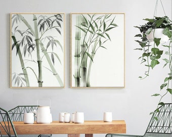 May include: Two rectangular wall art prints featuring watercolor-style bamboo stalks in shades of green and grey on a white background, each framed in a thin light wood border. The artwork depicts vertical bamboo stems with pointed leaves.