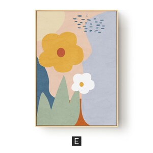May include: Abstract floral art print in a gold frame. The artwork features a large yellow flower with a red center, a smaller white flower, and green leaf shapes against a pastel background of pink, blue, and yellow.