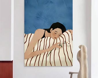 May include: An art print of a person lying in bed, holding a flower. The person is wearing a black top, resting on a striped pillow. The background is a textured blue. A wooden sculpture and stool are in the foreground.