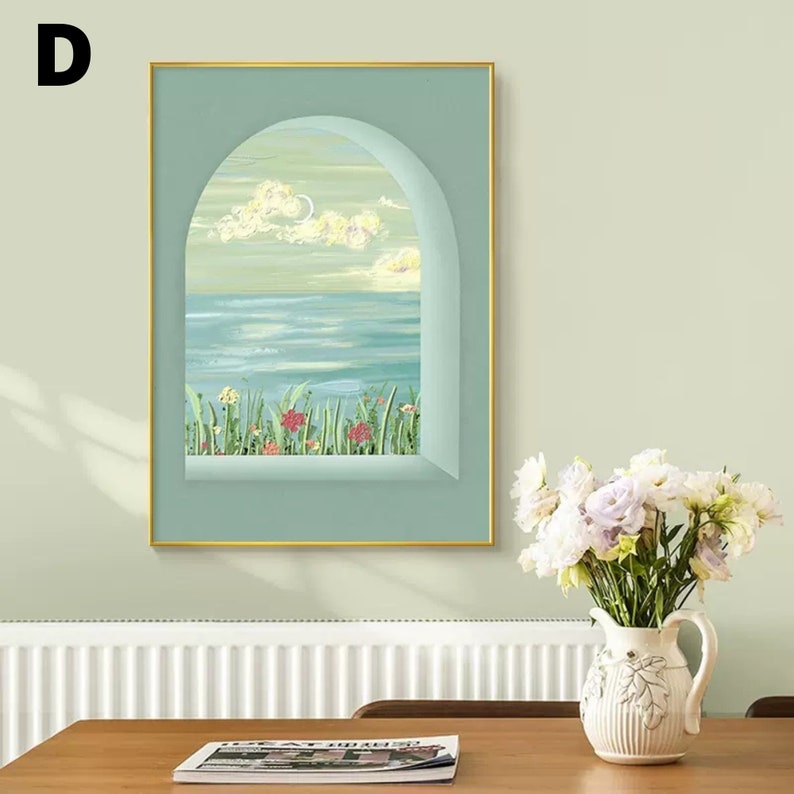 May include: A framed painting of a seascape viewed through an arched window. The painting features a blue ocean, a cloudy sky, and green grass with red flowers in the foreground.