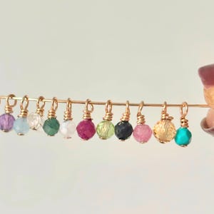 Puede incluir: Una taza de cerámica blanca con asa negra y el texto "But First, Coffee" en negrita negra. La taza se encuentra sobre un fondo neutro, resaltando su diseño sencillo.