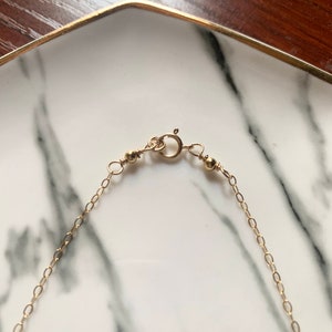 May include: A gold chain bracelet with a lobster clasp fastening. The bracelet features green and blue gemstone beads.