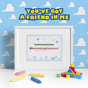 May include: A framed print with the text "You've Got A Friend In Me" in blue and yellow. The print features musical notes and cartoon illustrations. Colourful wooden blocks and crayons are in the foreground.