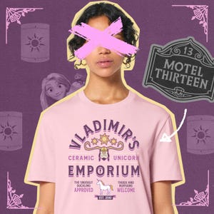 May include: Pink t-shirt with a graphic of a unicorn and the text "Vladimir's Ceramic Unicorn Emporium" with the text "The Snuggly Duckling Approved" and "Thugs and Ruffians Welcome" below the graphic.