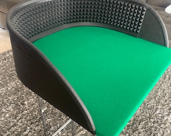 Puede incluir: Silla contemporánea curvada con asiento de fieltro verde y respaldo negro texturizado. La silla tiene una base geométrica cromada. El respaldo presenta un patrón de pequeños triángulos negros.