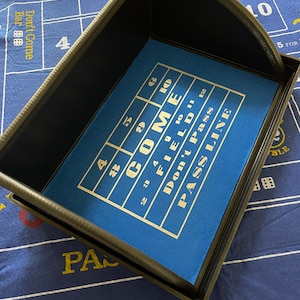 May include: A black plastic tray with a blue felt insert. The insert has a grid with numbers and the words "Come", "Field", "Don't Pass", and "Pass Line".
