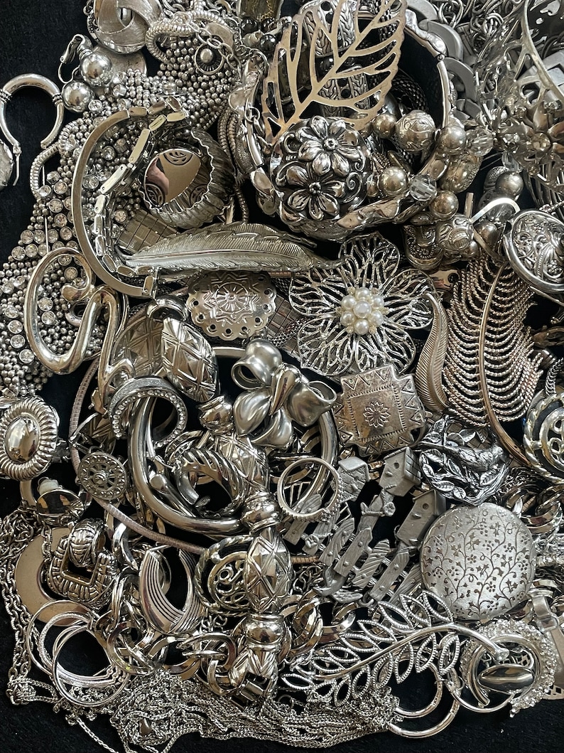 Puede incluir: Una gran colecci&oacute;n de joyas plateadas, incluyendo collares, pulseras, pendientes y broches. Las joyas est&aacute;n dispuestas en una pila, y muchas de las piezas est&aacute;n intrincadamente dise&ntilde;adas.