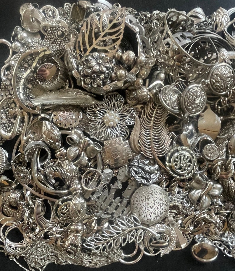 Puede incluir: Una gran colecci&oacute;n de piezas de joyer&iacute;a plateadas, incluyendo collares, pulseras, pendientes y broches. La joyer&iacute;a est&aacute; dispuesta en una pila ca&oacute;tica, con muchos dise&ntilde;os y estilos diferentes.