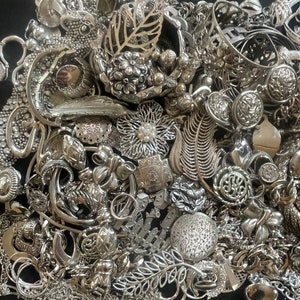 Puede incluir: Un mont&oacute;n grande de joyas plateadas, incluyendo collares, pulseras, pendientes y broches. Las joyas est&aacute;n dispuestas en un patr&oacute;n aleatorio, y algunas piezas se superponen. Las joyas est&aacute;n hechas de metal y tienen una variedad de dise&ntilde;os.