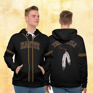 May include: Black baseball hoodie with gold trim and a Native American design. The front of the hoodie says "NATIVE" in a varsity style font. The back of the hoodie has a feather design with the text "TEAM" on the top left and "TRIBAL" on the top right.