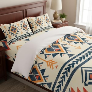 May include: A bedding set featuring a cream-colored duvet cover and two matching pillowcases, all decorated with a repeating geometric pattern in navy blue, orange, and yellow, including diamond shapes, arrow motifs, and chevron borders.