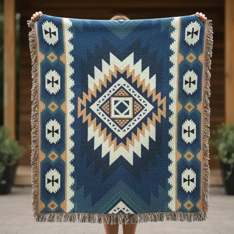 Op de afbeelding: Een geweven plaid met een groot centraal ruitpatroon in marineblauw, cr&egrave;me en beige tinten. Het ontwerp bevat geometrische vormen en herhalende motieven met een franjerand aan de boven- en onderkant van de deken.