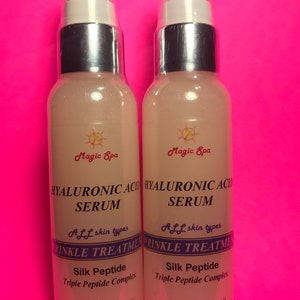 May include: Two clear glass bottles with silver caps and a pink liquid inside. The bottles are labelled "Magic Spa Hyaluronic Acid Serum" and "Aff skin types Wrinkle Treatment Silk Peptide Triple Peptide Complex Net Wt. 2 fl. oz. (60 ml)"