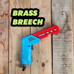 May include: A blue and red plastic tool with the words "BRASS BREECH" printed on a black sticker. The tool has a trigger and a barrel.