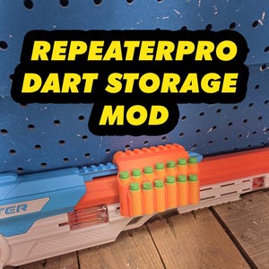 May include: An orange plastic dart storage mod attached to a blue and white toy blaster. The storage unit holds twelve foam darts with green tips. The text REPEATERPRO DART STORAGE MOD is displayed in yellow letters against a black background.