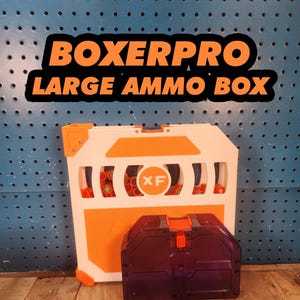 May include: White and orange "Boxerpro Large Ammo Box" with a purple ammo container. The large box has a handle and several openings. The text "XF" is visible on the box. The background is a blue pegboard.