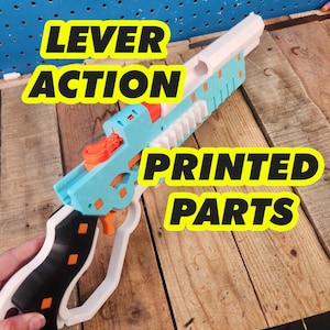 May include: A 3D printed lever-action toy gun with a white barrel, blue body, and black grip. The gun has orange accents and the words "LEVER ACTION" and "PRINTED PARTS" are printed on the image.