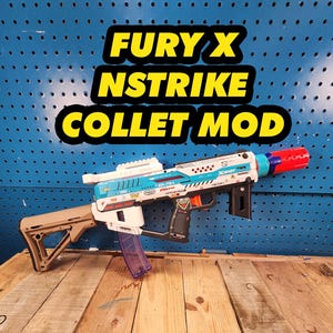 May include: A white, blue, and black Nerf Fury X Nstrike toy gun with a tan stock and a clear magazine. The gun has a red barrel extension and the text "X-SHOT" and "ZL-754" printed on it.