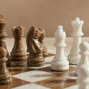 Może przedstawiać: Zestaw trzech ceramicznych kubk&oacute;w z nakrapianym, matowym wykończeniem. Kubki są w odcieniach kremu, jasnoszarym i ciemnoszarym. Każdy kubek ma prosty, minimalistyczny design.