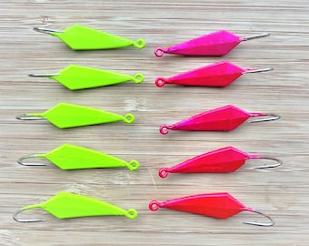 May include: Eight fishing jig lures, four are bright green and four are bright pink. The lures are diamond shaped with a hook on the end.