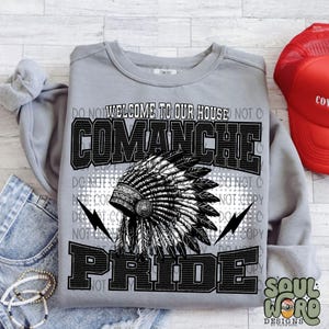 May include: A gray sweatshirt with a black and white graphic design. The graphic features a headdress with feathers and the text "Welcome to our house Comanche Pride".