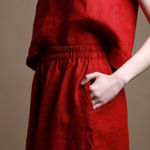 Puede incluir: Una falda de lino roja con cintura el&aacute;stica y un bolsillo lateral.