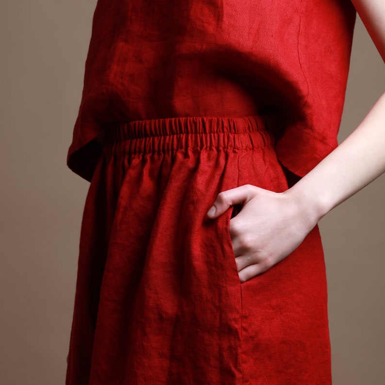 Puede incluir: Una falda de lino roja con cintura el&aacute;stica y un bolsillo lateral.