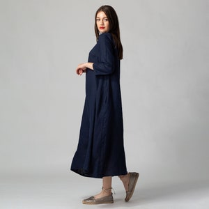 Minimalist maxi linen dress in Night Blue. Fitted in the upper part it flared generously down to the ankles. It features ¾ set in sleeves and side pockets. The wide optional belt offers various styling options.