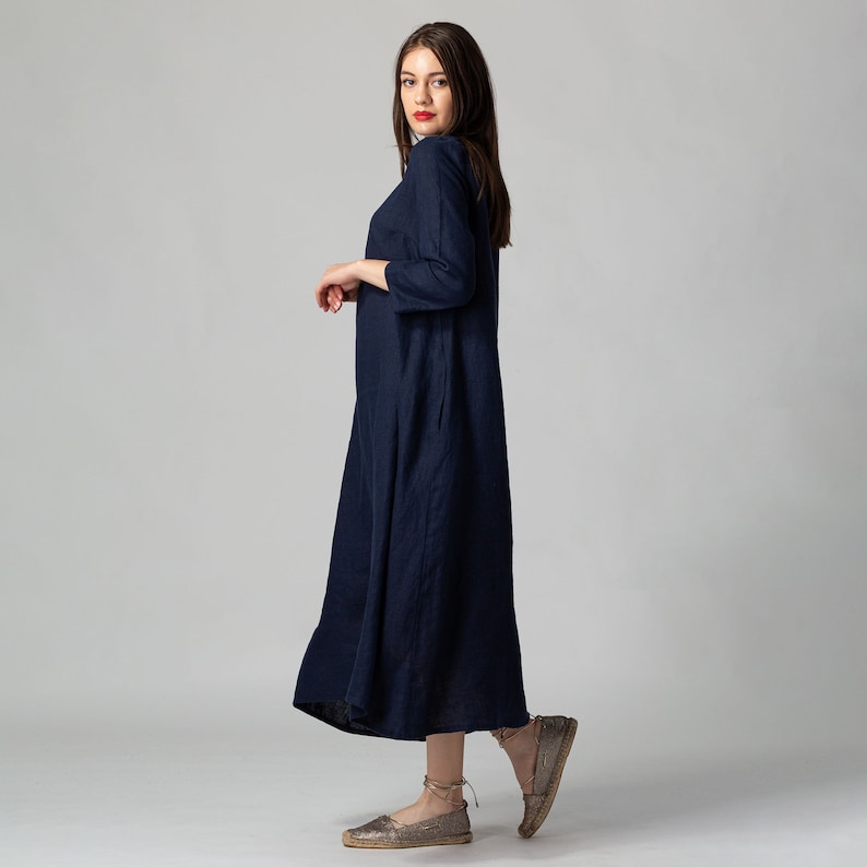 Minimalist maxi linen dress in Night Blue. Fitted in the upper part it flared generously down to the ankles. It features ¾ set in sleeves and side pockets. The wide optional belt offers various styling options.