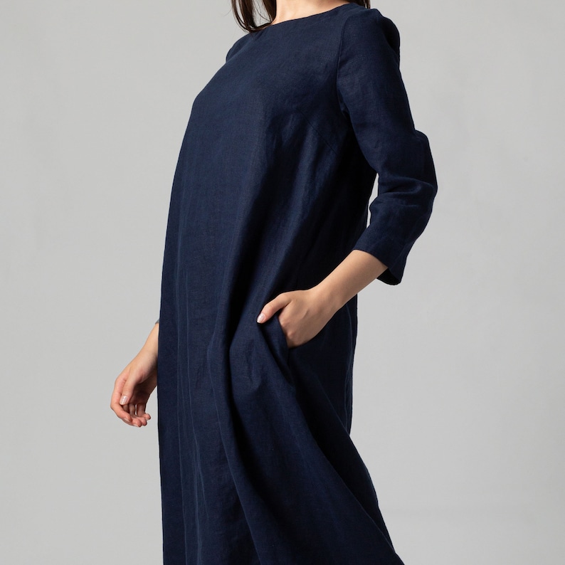 Minimalist maxi linen dress in Night Blue. Fitted in the upper part it flared generously down to the ankles. It features ¾ set in sleeves and side pockets. The wide optional belt offers various styling options.
