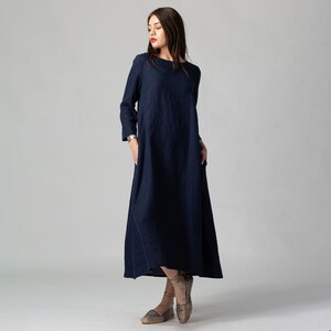 Minimalist maxi linen dress in Night Blue. Fitted in the upper part it flared generously down to the ankles. It features ¾ set in sleeves and side pockets. The wide optional belt offers various styling options.